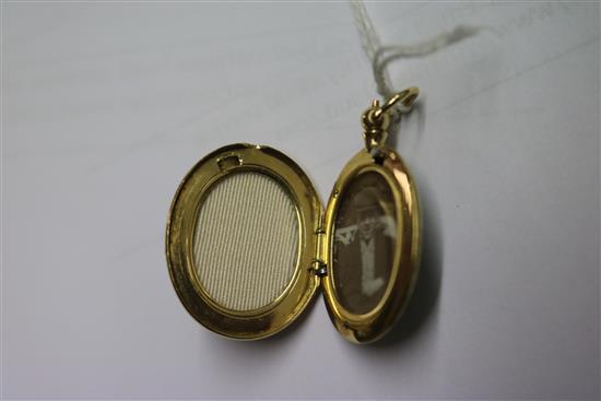 A 15ct gold and green enamel oval locket pendant, 30mm.